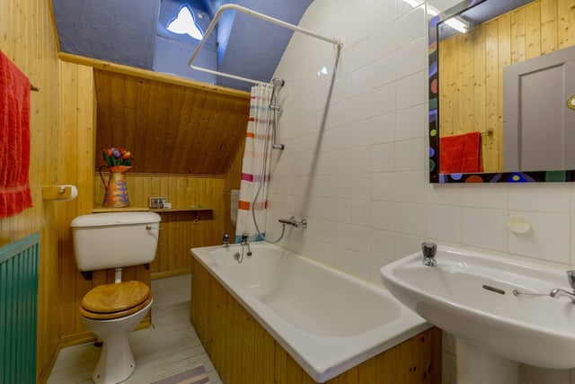 The colourful family bathroom with feature window.