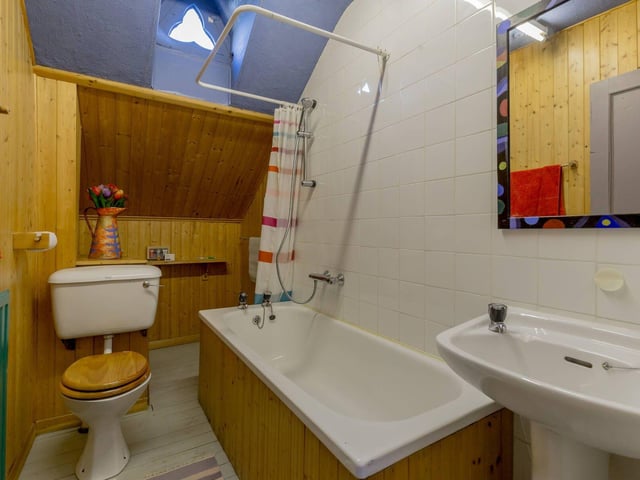 The colourful family bathroom with feature window.