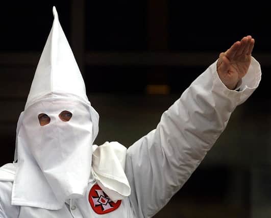 A Klansman raises his left arm during a "white power" chant at a Ku Klux Klan rally in 2000 (Getty Images)