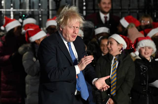 Boris Johnson applauds a group of young singers as he attends the switch-on of the Downing Street Christmas tree lights (Picture: Justin Tallis/AFP via Getty Images)
