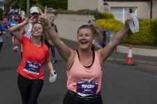 Runners wave as they reach the four mile mark in Craigentinny on Sunday morning