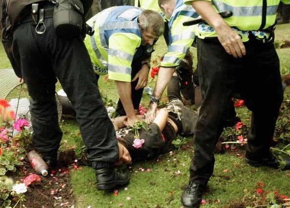 A protesters is detained by police officers on Princes Street on July 4 2005 in Edinburgh, Scotland. The protest is one of several organised protests that lead up to the G8 Summit which begins on July 6 in Gleneagles.