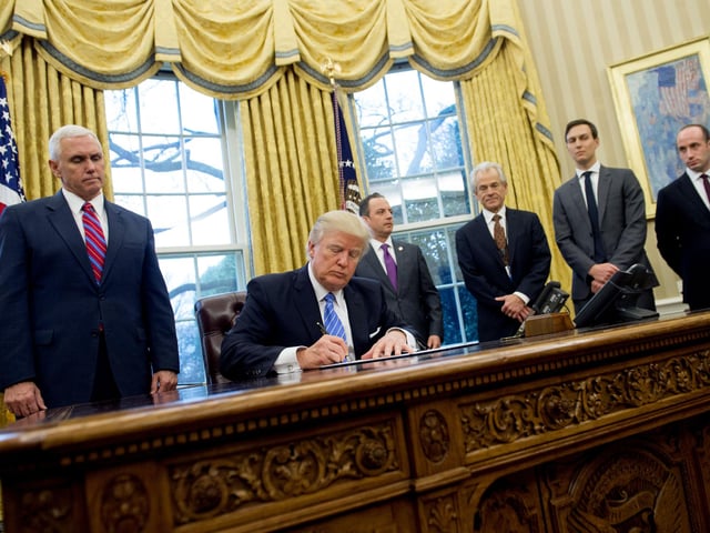 On his first day in office, President Donald Trump signs an executive order alongside White House Chief of Staff Reince Priebus (C), US Vice President Mike Pence (L), National Trade Council Advisor Peter Navarro (3rd R), Senior Advisor Jared Kushner (2nd R) and Senior Policy Advisor Stephen Miller in the Oval Office of the White House in Washington.  His Executive Order - witnessed by his male staff - was a ban on federal money going to international groups that perform or provide information on abortions.