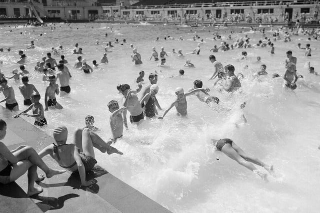 Holiday makers at Portobello Outdoor Swimming Pool having fun in the waves in July 1955.