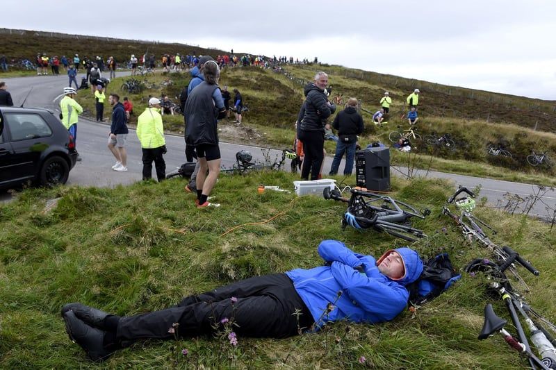 A member of the public rests prior to the cyclists arrive on Cairn O' Mount during stage eight.