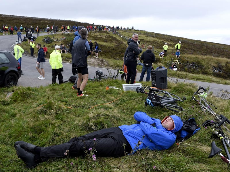 A member of the public rests prior to the cyclists arrive on Cairn O' Mount during stage eight.