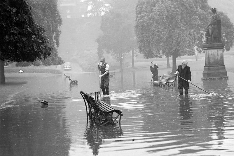 Torrential rain during a thunderstorm took just 15 minutes to cause flood damage in Edinburgh in July 1953. Workmen repairing damage in Princes Street Gardens.