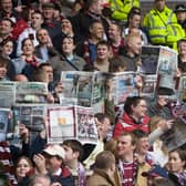 Hearts fans brought newspapers into Ibrox to celebrate their team finishing ahead of Rangers prior to the season's final game. Picture: SNS