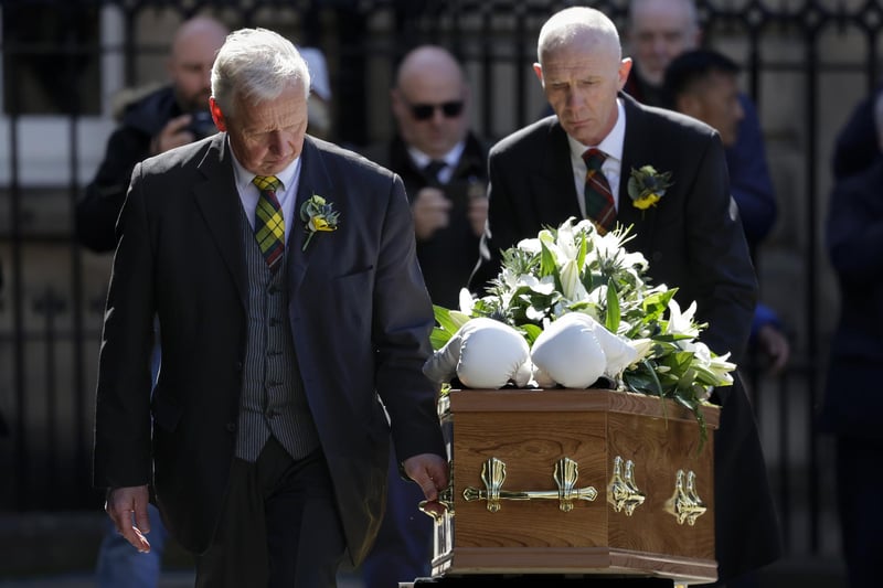 White boxing gloves lie on the coffin as it arrives for the funeral