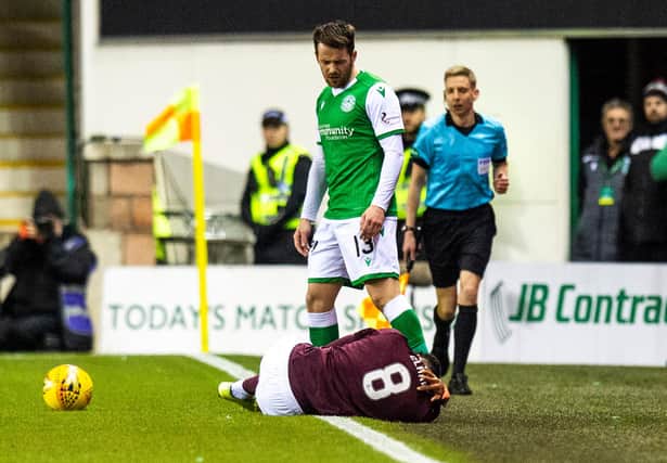 Hearts midfielder Sean Clare is grounded after a challenge from Hibs' Marc McNulty
