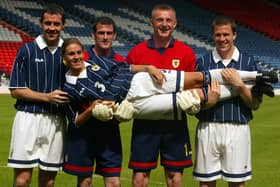 Julie Fleeting modelling a new strip with David Weir, Paul Gallacher, Robert Douglas and Gary Caldwell in May 2002. A chauvinistic picture that would not be considered appropriate nowadays.
