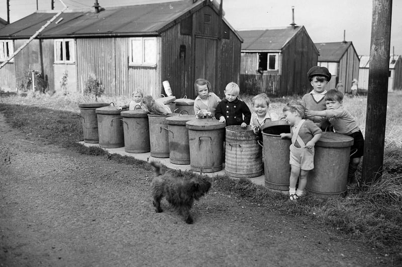 Children playing at the line of rubbish bins in Sighthill Camp in 1954.