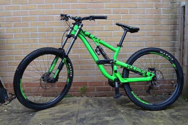 A bright green Scott Voltage bike with Shimano Zee Brakes.