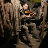 A Ukrainian soldier plays the violin in a dugout on the frontline with Russia-backed separatists, not far from Gorlivka, in the Donetsk region, in December (Picture: Anatolii Stepanov/AFP via Getty Images)