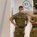 Military personel gesture at a temporary Covid-19 vaccination centre set up at the Royal Highland Showground near Edinburgh, Scotland, on February 4, 2021. Photo by Andrew Milligan via Getty Images