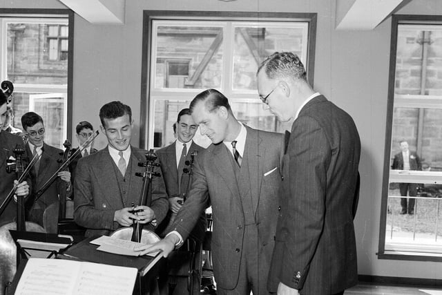 The Duke of Edinburgh with members of the orchestra and conductor Dr J F Fairbairn in the Fettes College music room during the royal visit in July 1955