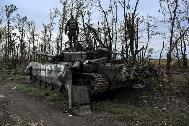 A Ukrainian soldier stands on top of an abandoned Russian tank near a village on the outskirts of Izyum, Kharkiv region, eastern Ukraine (Picture: Juan Barreto/AFP via Getty Images)