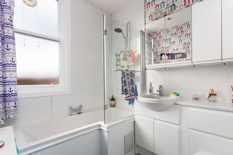 The contemporary family bathroom featuring a traditional white suite and electric shower over bath.