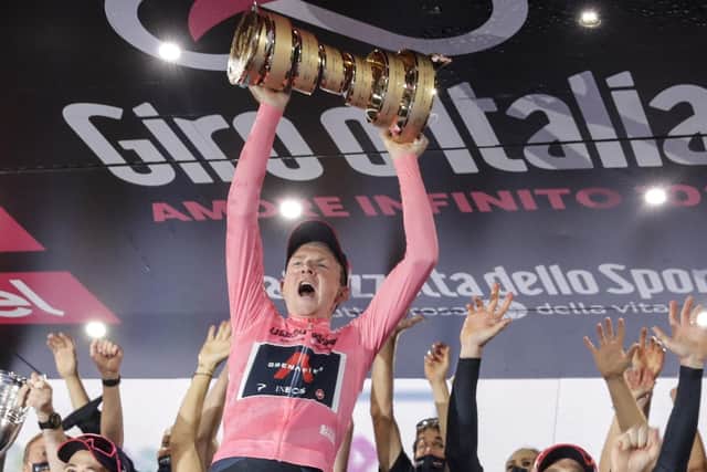 Britain's Tao Geoghegan Hart holds up the trophy after winning the Giro d'Italia cycling race, in Milan, Italy, Sunday, Oct. 25, 2020. (AP Photo/Luca Bruno)