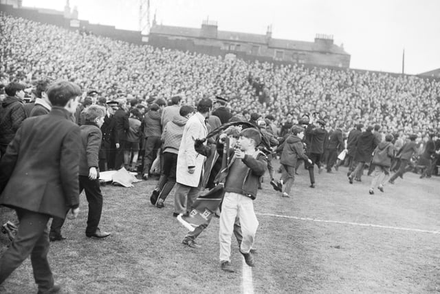 Police are swamped by supporters invading the pitch at Tynecastle Park, Edinburgh, during the Hearts v Celtic match in March 1966.