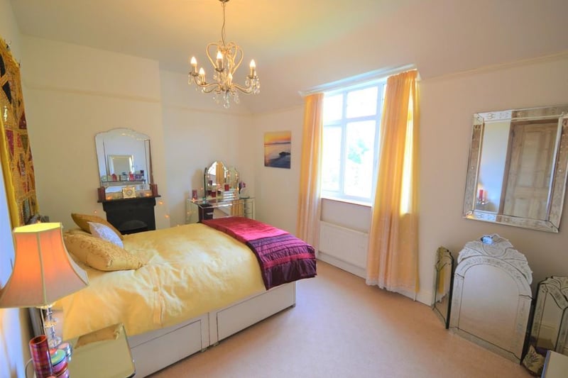 A spacious and attractively presented double bedroom with a pleasant view from a front facing UPVC double glazed window, having a feature cast iron fireplace with tiled hearth, and a built in storage cupboard with hanging rail and light.