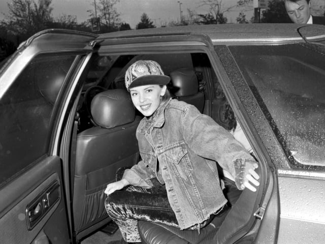 Australian pop singer Kylie Minogue gets into her car after arriving at Edinburgh Airport in October 1989.