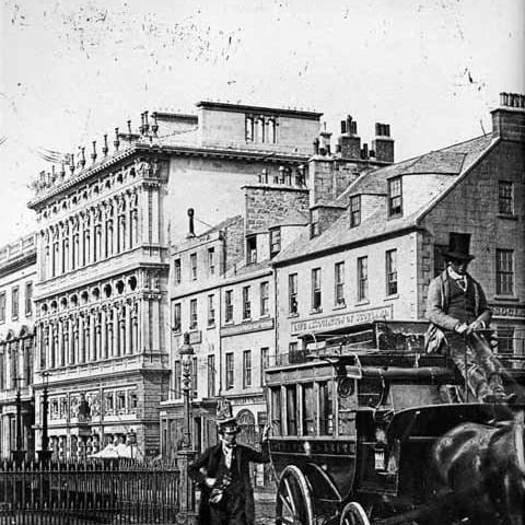 A stagecoach waiting on Princes Street. The newly-built Life of Association head office (since demolished) can be seen in the background.