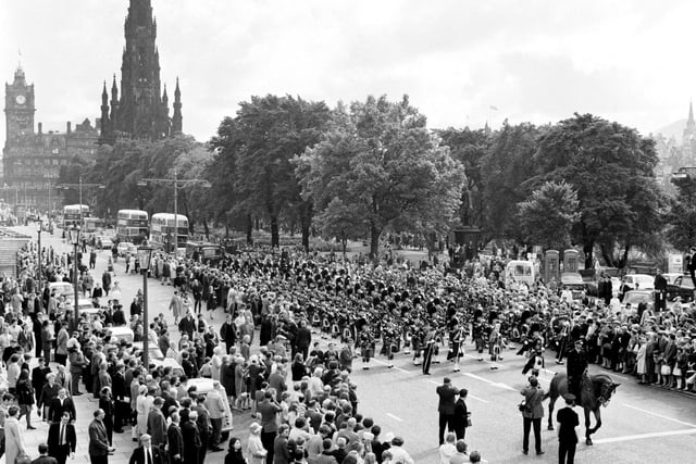 Crowds gather to watch the Edinburgh City Police Pipe Band as it marches along Princes Street during the Edinburgh International Festival in August 1966.