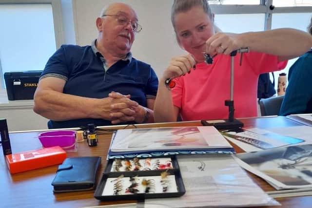 Ron Harvey from Edinburgh watching a student at the West Lothian Angling Association ladies fly tying session