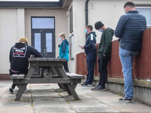 Young people are seen queuing outside a mobile vaccine unit on May 13, 2021 in Lossiemouth, Scotland. (Photo by Peter Summers/Getty Images)