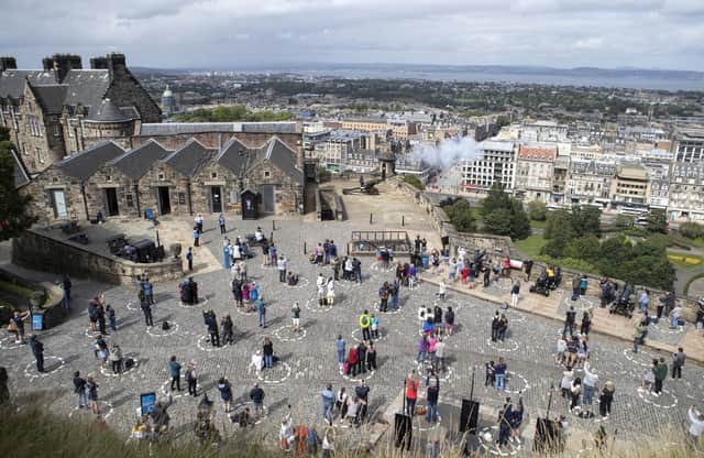 Visitors at Edinburgh Castle stand socially distanced in marked out circles