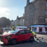 Fire crew seen pushing a smashed red car on Easter Road, Edinburgh (Photo: Beth Murray).
