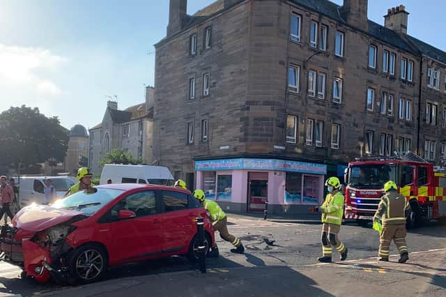 Fire crew seen pushing a smashed red car on Easter Road, Edinburgh (Photo: Beth Murray).