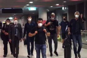 This screen grab taken from AFPTV shows Serbia's Novak Djokovic, third from left, preparing to depart from Melbourne Airport