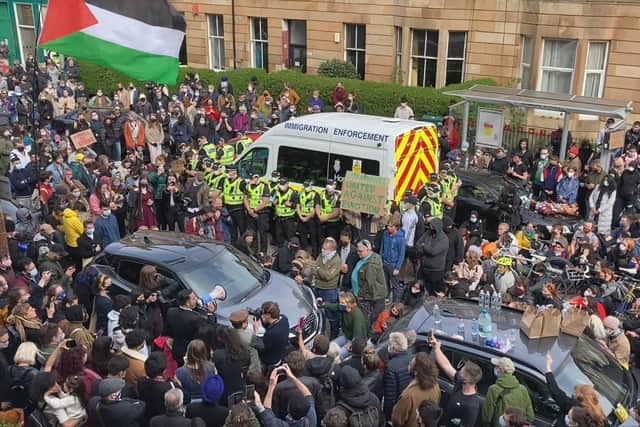 A large crowd of people in Glasgow's Kenmure Street prevented efforts to deport two men