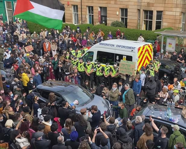 A large crowd of people in Glasgow's Kenmure Street prevented efforts to deport two men