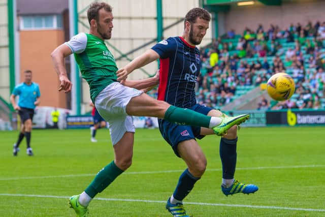 Christian Doidge battles with Alex Iacovitti during Hibs' 3-0 win over Ross County at Easter Road in August. Picture: SNS