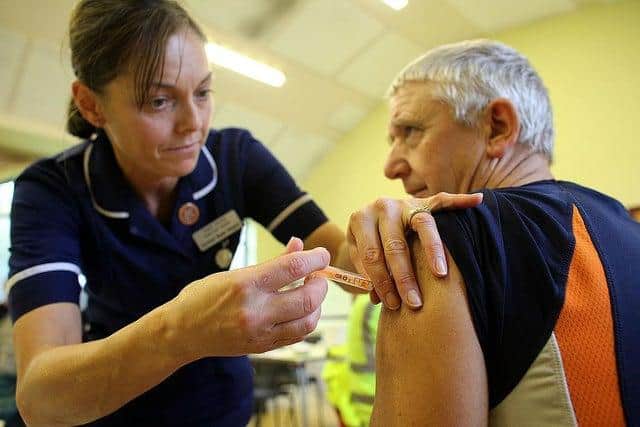 A flu vaccination being administered