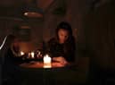 People sit in a café without power in Lviv, Ukraine. Once a safe haven for refugees, Russian attacks have plunged the city into darkness and cold (Picture: Jeff J Mitchell/Getty Images)