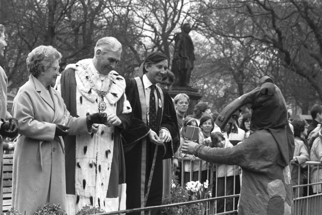 University Rector David Steel and Lord Provost Tom Morgan hand over some money to a 'dragon' in the Edinburgh University Student Charities Week parade along Princes Street in April 1984.