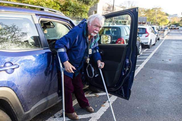 Hugh Munro shows how the new parking spaces means he has to get out of his car into the road   Picture: Lisa Ferguson