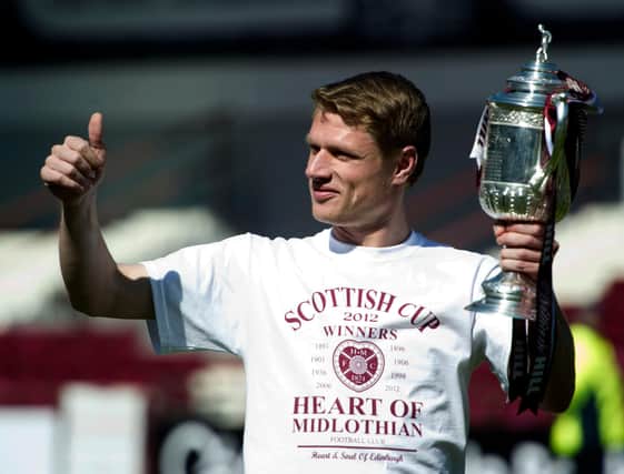 Hearts captain Marius Zaliukas is all smiles after bringing the Scottish Cup trophy back to Tynecastle to celebrate with the fans in 2012. Picture: SNS