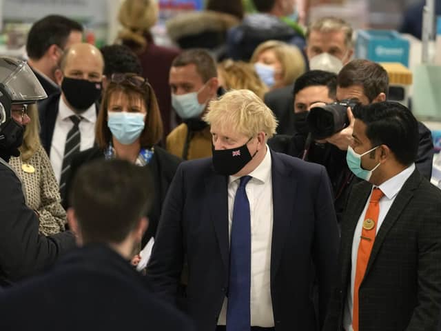 Prime Minister Boris Johnson visits a vaccination centre at a pharmacy in his constituency Uxbridge, London, on Monday. (AP Photo/Frank Augstein)