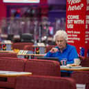 A customer at Buzz Bingo is enjoying a cup of tea and  snack as she plays the game.