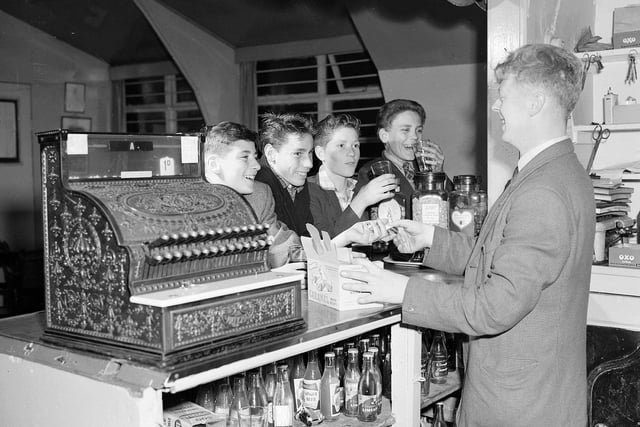 Members of the Fettesian-Lorettonian Boys Club (open to pupils from Fettes and Lorretto schools) in the canteen with the cash register showing a charge of 1d.