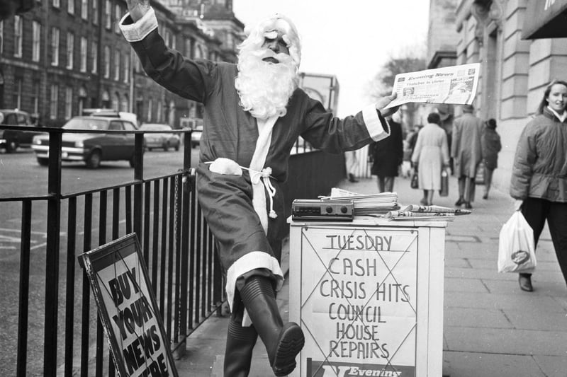 An Evening News vendor gets into the Christmas spirit by dressing as Santa Claus at his pitch outside Frasers department store in Princes Street Edinburgh, December 1986.