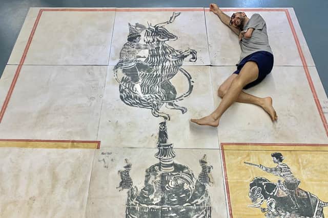 Photo issued by Mohammad Barrangi of himself lying next to one of his prints. The artist born without the use of his left arm, who has competed in the Paralympics, is to have his artwork exhibited at the Edinburgh Printmakers from January next year.