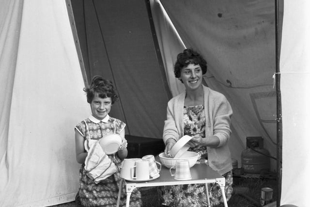Mum and daughter wash the dishes outside their tent at the Granton campsite on Marine Drive in July 1966.