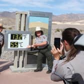 National Park Service Rangers are photographed next to a digital display of an unofficial heat reading at Furnace Creek Visitor Center in Death Valley National Park in Death Valley, California earlier this month (Picture: Ronda Churchill/AFP via Getty Images)
