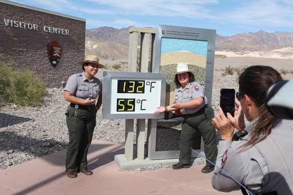 National Park Service Rangers are photographed next to a digital display of an unofficial heat reading at Furnace Creek Visitor Center in Death Valley National Park in Death Valley, California earlier this month (Picture: Ronda Churchill/AFP via Getty Images)